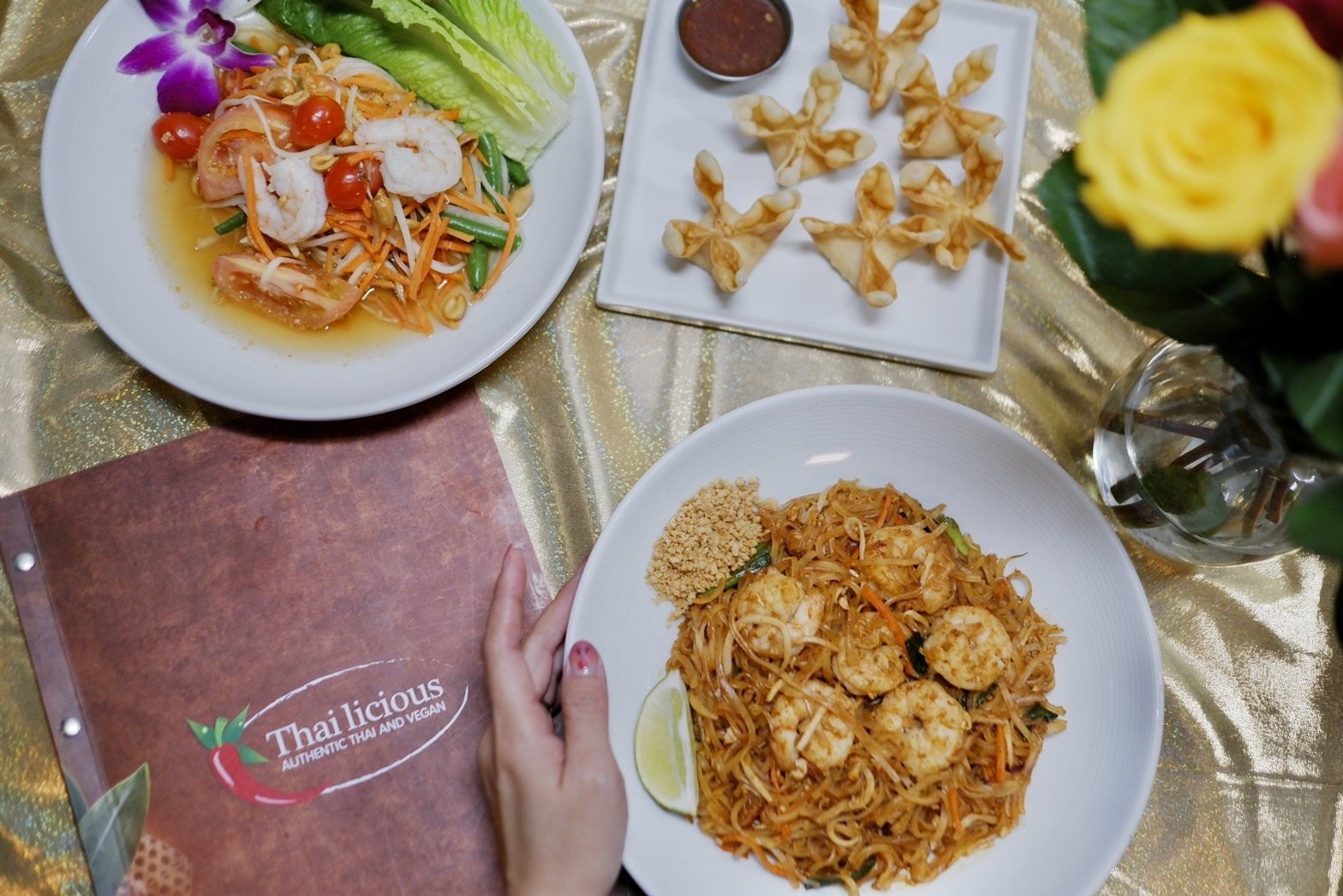 A spread of authentic Thai dishes including som tum papaya salad and pad thai at Thailicious